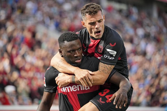 Leverkusen&#039;s scorer Victor Boniface, left, celebrates with Leverkusen&#039;s Granit Xhaka, right, after scoring the opening goal during the German Bundesliga soccer match between Bayer Leverkusen ...