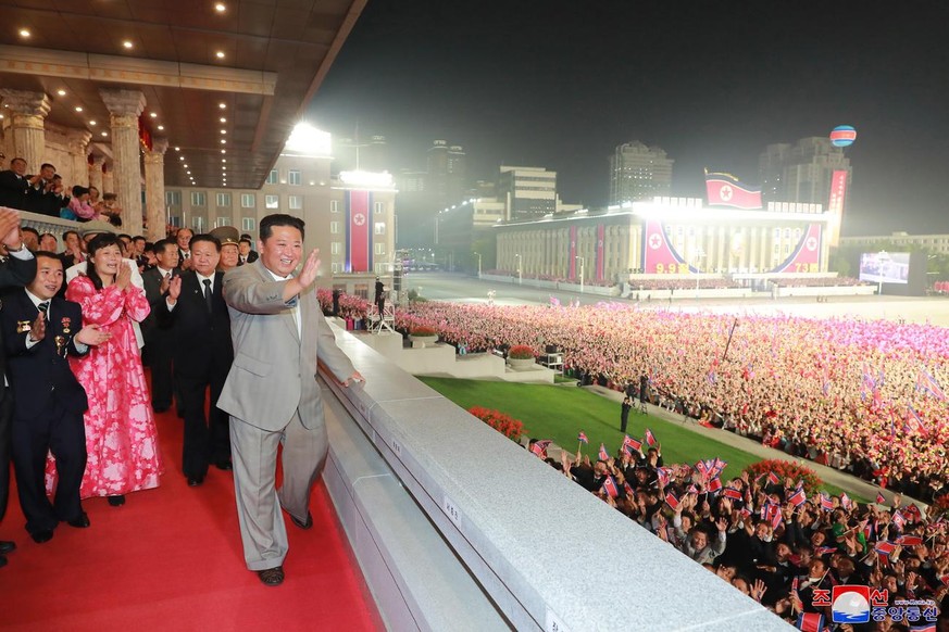 epa09456635 A photo released by the official North Korean Central News Agency (KCNA) shows North Korean leader Kim Jong-un (front) waving at the crowd during a military parade at Kim Il-sung Square in ...