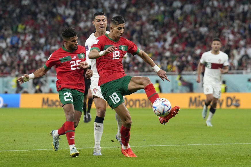 Portugal&#039;s Cristiano Ronaldo challenges for the ball with Morocco&#039;s Jawad El Yamiq, right, during the World Cup quarterfinal soccer match between Morocco and Portugal, at Al Thumama Stadium  ...