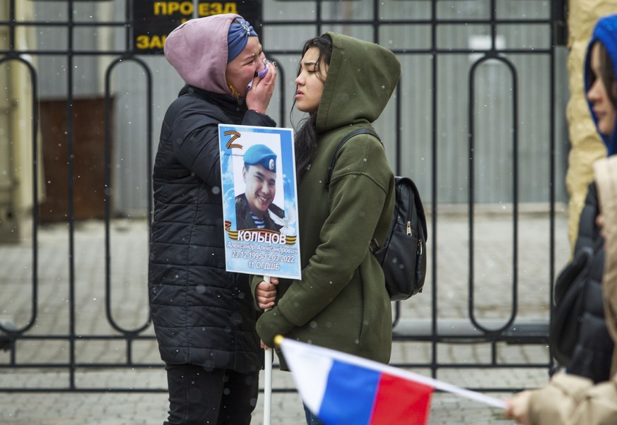 Women cry as they hold a portrait of Russian Army serviceman Alexander Koltsov, who was killed during fighting in Ukraine, during the Immortal Regiment march in Ulan-Ude, the regional capital of Burya ...