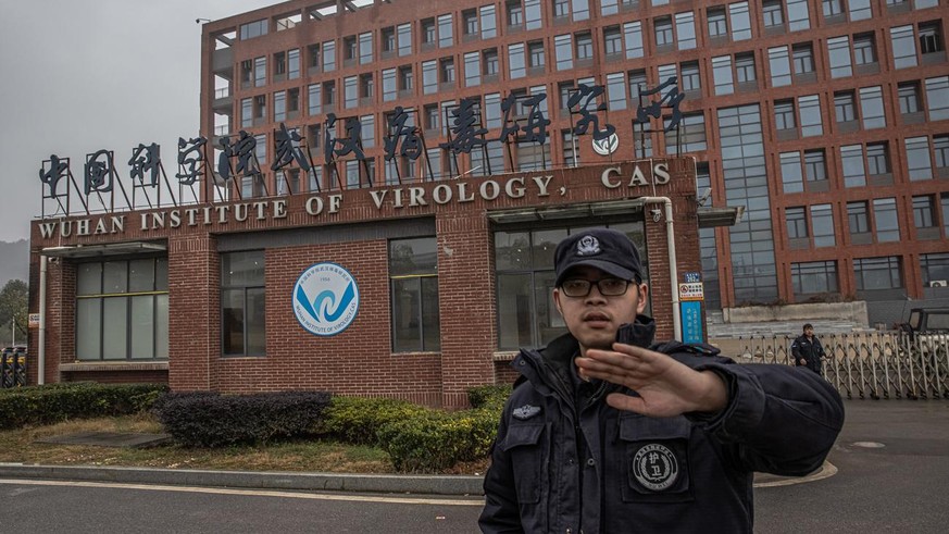 epa08968097 A security staff tries to stop the photographer from taking pictures of Wuhan Institute of Virology in Wuhan, China, 27 January 2021. The international expert team from the World Health Or ...