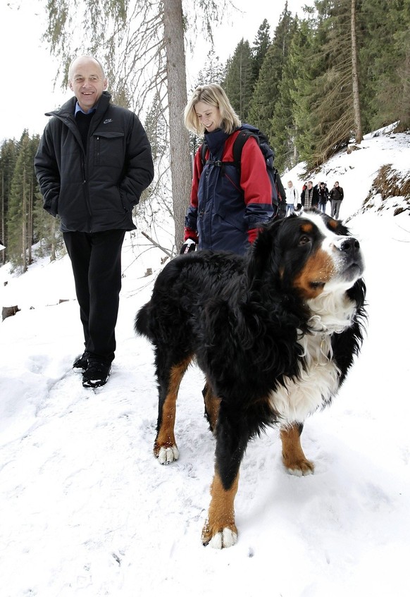 Bundesrat Ueli Maurer, links, begegnet einem Hund waehrend einer Wanderung mit Journalisten am Montag, 28. Dezember 2009 in Adelboden. (KEYSTONE/Peter Klaunzer)