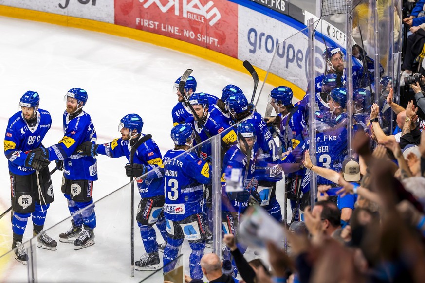 Le capitaine Julien Sprunger (HCFG), gauche, fete la victoire avec ses coequipiers a l'issue du but victorieux lors du premier overtime du sixieme match de la finale des play-off du championnat s ...