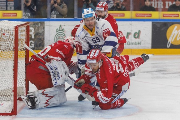 EV Zug Stuermer Dario Simion gegen SC Rapperswil-Jona Lakers Torhueter Melvin Nyffeler und Verteidiger David Aebischer waehrend dem Eishockey-Meisterschaftsspiel der National League zwischen den SC Ra ...