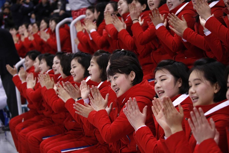 Ces supportrices nord-coréens applaudissent avant le tour préliminaire du match de hockey féminin opposant la Suisse et les Corées aux Jeux olympiques d'hiver de 2018 en Corée du Sud