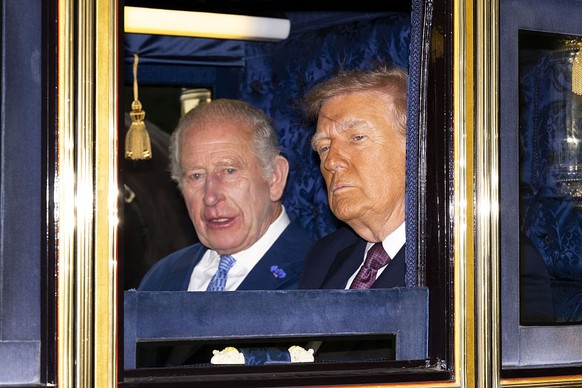 WINDSOR, ENGLAND - SEPTEMBER 17: King Charles III and U.S. President Donald Trump sit in a carriage during a procession through Windsor Castle during the state visit by the President of the United Sta ...