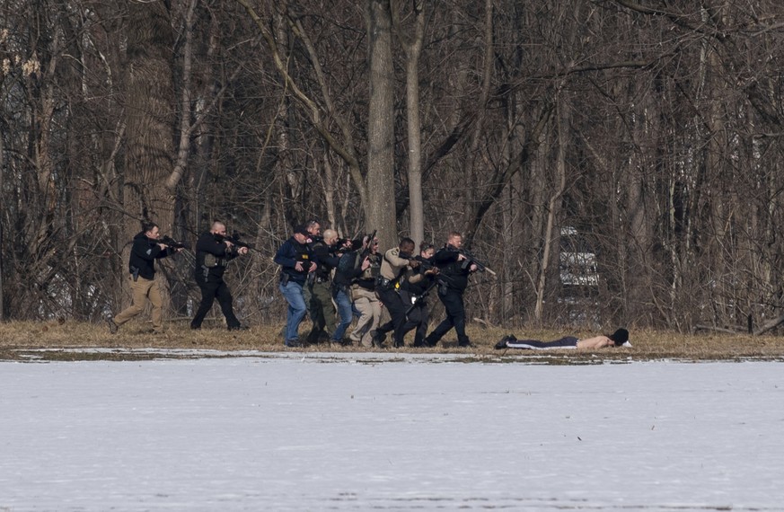 Police approach a person of interest on the south bank of the North River in Bridgewater, Va. following a shooting at Bridgewater College Tuesday, Feb. 1, 2022. (Daniel Lin/Daily News-Record Via AP)