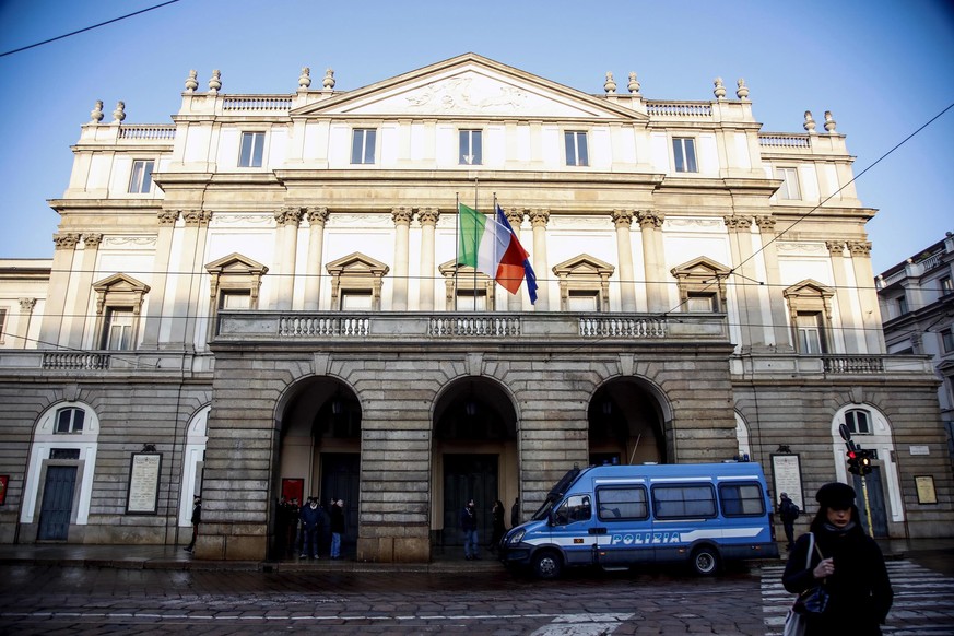 epa10353253 Police stand guard as workers clean up the outside facade entrance of La Scala Theater which had been defaced by activists of the environmental group 'Ultima Generazione' in Milan, Italy,  ...