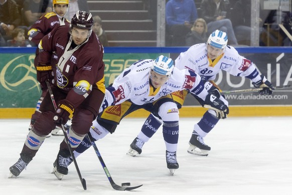 Geneve-Servette&#039;s defender Henrik Toemmernes, left, vies for the puck with Zug&#039;s forward Gregory Hofmann, centre, past Zug&#039;s forward Sven Senteler, right, during a National League regul ...