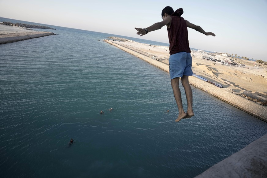A holiday maker jumps in the beach of al-Alamein city, at the Mediterranean Sea in Egypt, Thursday, August. 8, 2024. (AP Photo/Amr Nabil)
