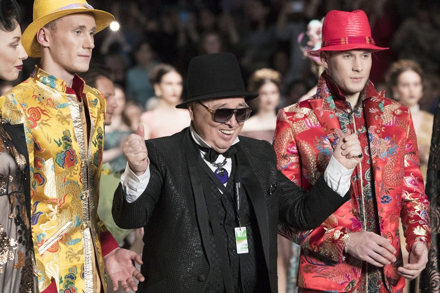 FILE - Designer Vyacheslav &quot;Slava&quot; Zaitsev, center left, reacts after displaying his creations during Fashion Week in Moscow, Russia, Saturday, March 10, 2018. Zaitsev, Russia&#039;s most fa ...