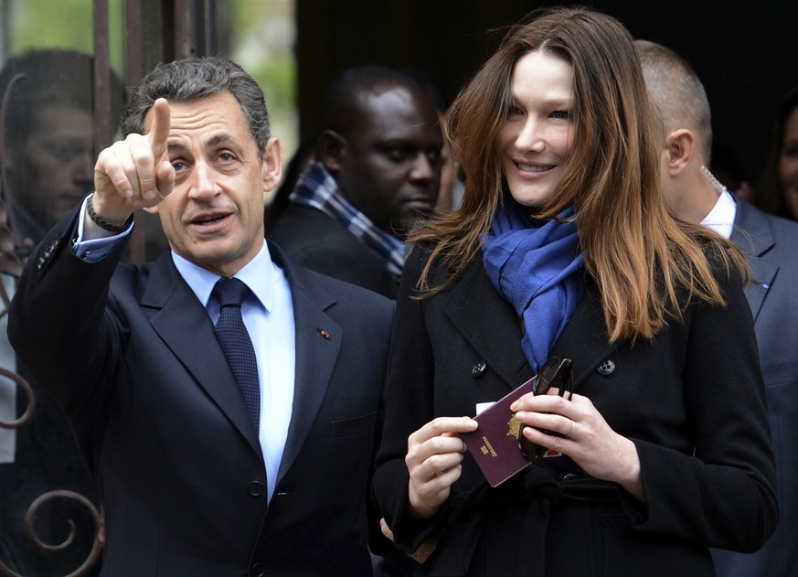 French President and UMP party candidate Nicolas Sarkozy, left, and his wife Carla Bruni-Sarkozy leave a polling station after casting their votes in the first round of French presidential elections i ...