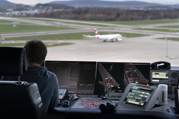 Ein Mitarbeiter von Skyguide kontrolliert die Monitore und hat Blick auf das Flugfeld, bei Skyguide im Tower des Flughafen Zuerich Kloten, aufgenommen am Mittwoch, 23. November 2022. Im Tower am Flugh ...