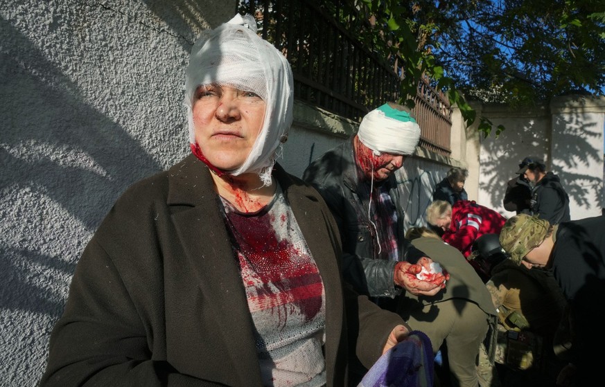People receive medical treatment at the scene of Russian shelling, in Kyiv, Ukraine, Monday, Oct. 10, 2022. Two explosions rocked Kyiv early Monday following months of relative calm in the Ukrainian c ...