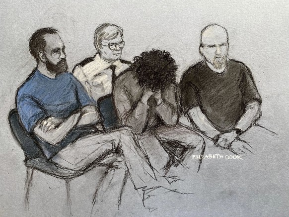 This court artist drawing by Elizabeth Cook shows 17-year-old Axel Rudakubana, center, covering his face as he appeared in the dock at Liverpool Crown Court in Liverpool, England, Thursday Aug. 1, 202 ...