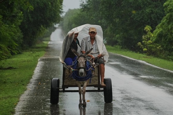 A couple rides under plastic on a donkey-pulled cart in the rain before the arrival of Hurricane Melissa in Canizo, a vilage in Santiago de Cuba, Tuesday, Oct. 28, 2025. (AP Photo/Ramón Espinosa)
Cuba ...