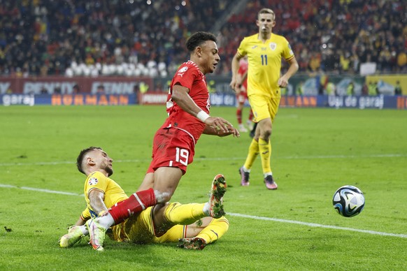 Switzerland&#039;s Dan Ndoye, top, and Romania&#039;s Denis Dragus in action during the UEFA Euro 2024 qualifying group I soccer match between Romania and Switzerland at the National Arena stadium in  ...