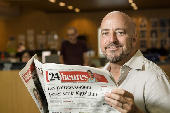 Claude Ansermoz, le nouveau redacteur en chef du journal 24heures pose dans la redaction avec un exemplaire du journal ce mercredi 23 aout 2017 a Lausanne. (KEYSTONE/Jean-Christophe Bott)