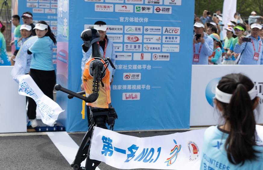 epa12040319 ?Tian Gong?, the first place robot, crosses the finish line during a marathon in Beijing, China, 19 April 2025. China hosts the world?s first all-robot marathon in Beijing, showcasing the  ...