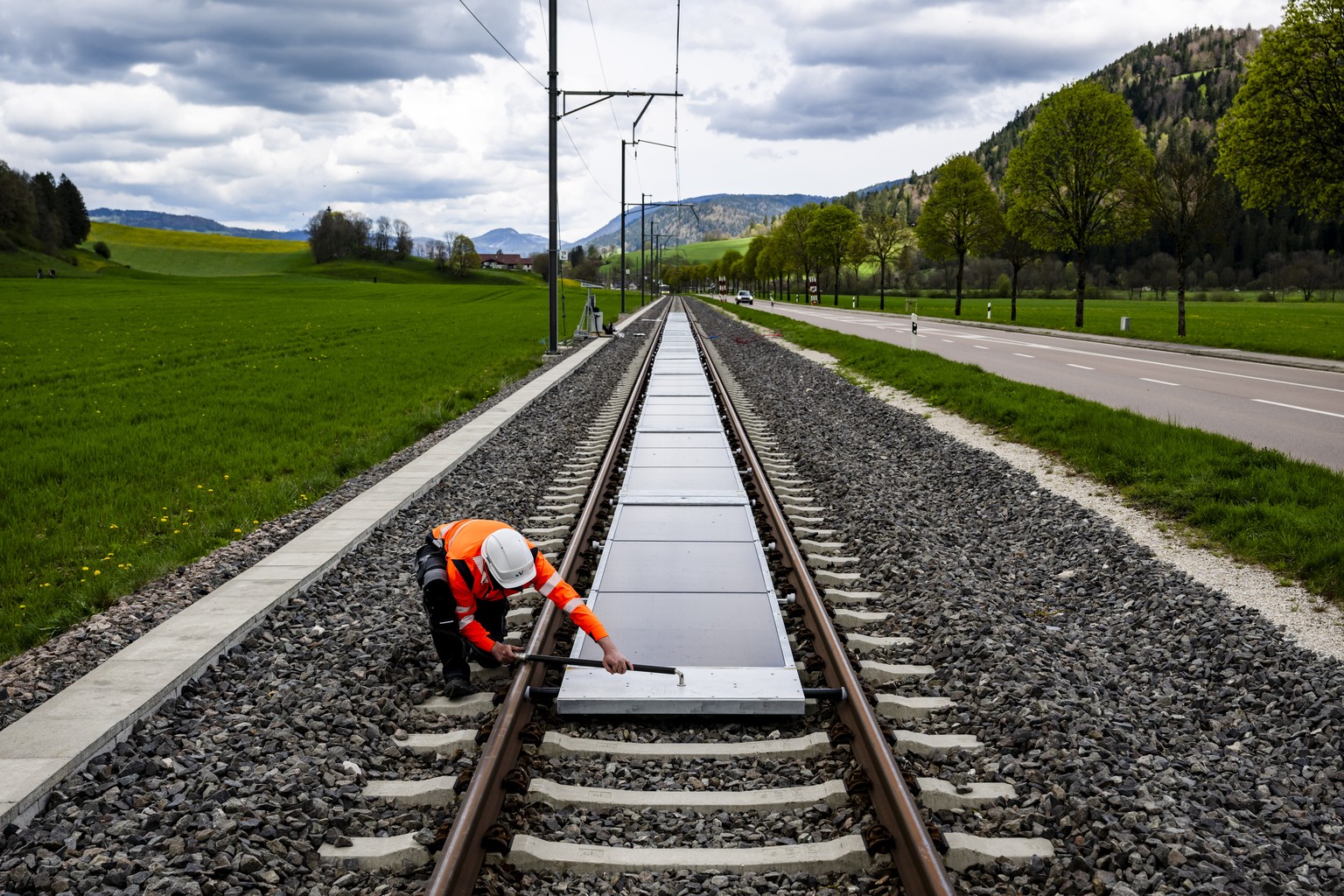 KEYPIX - Un ouvrier installe la premiere centrale solaire amovible sur voie ferree ouverte au trafic de l&#039;entreprise Sun Ways le mardi 22 avril 2025 a Buttes dans la commune de Val-de-Travers. (K ...
