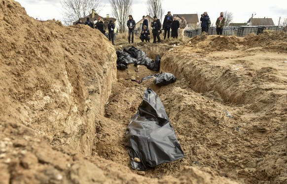 epaselect epa09870772 Bodies of civilians in plastic bags lay in a mass grave in Bucha city, which was the recaptured by the Ukrainian army, Kyiv (Kiev) area, Ukraine, 04 April 2022. More than 410 bod ...