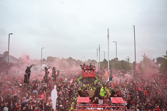 Liverpool's players celebrate with the Premier League trophy during an open-top bus victory parade for Liverpool's Premier League title win, in Liverpool, north-west England on May 26, 2025. ...