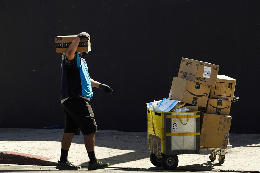 FILE - An Amazon worker delivers boxes in Los Angeles on Oct. 1, 2020. California is suing Amazon, accusing the company of violating the state���s antitrust and unfair competition laws by stifling com ...