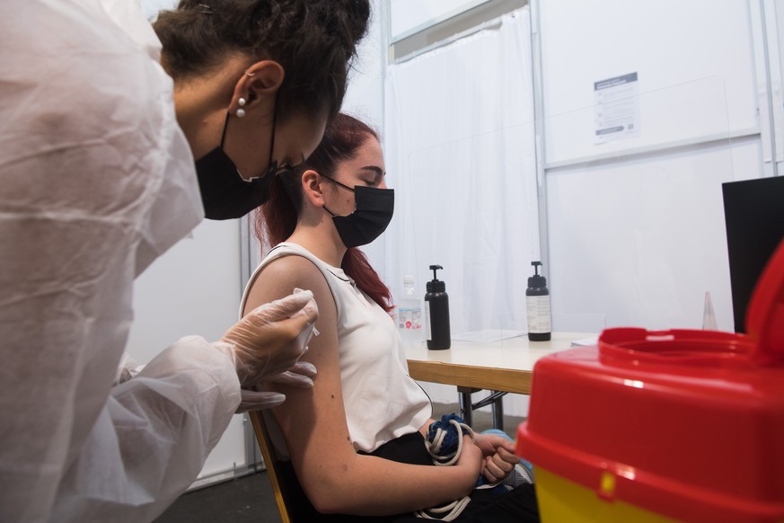 Eine junge Frau erhaelt im Impfzentrum von Giubiasco am Dienstag, 29. Juni 2021, ihre Corona-Impfung. Im Tessin werden zurzeit junge Leute in zwei Gruppen fuer unter 16-Jaehrige und ueber 16-Jaehrige  ...
