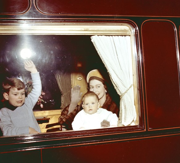 Queen Elizabeth II with her two sons, Prince Andrew and baby Prince Edward, driving from Euston Station in London on return from Balmoral. (Photo by PA Images via Getty Images)