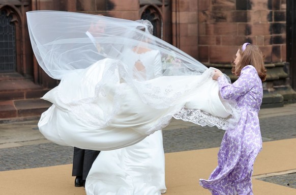 CHESTER, ENGLAND - JUNE 07: The bridal veil of Olivia Henson blows in the wind as she arrives for her wedding to Hugh Grosvenor, Duke of Westminster at Chester Cathedral on June 07, 2024 in Chester, E ...