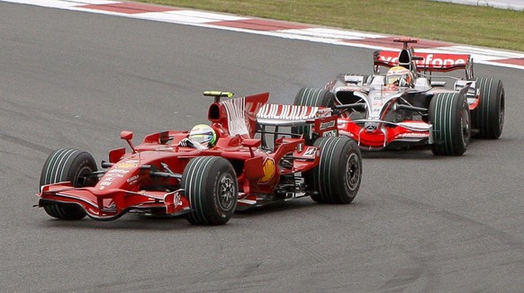 epa01517624 Brazilian Formula One driver Felipe Massa of Ferrari steers his car ahead of the British Formula One driver Lewis Hamilton of McLaren Mercedes after the start of the at the Fuji Speedway r ...