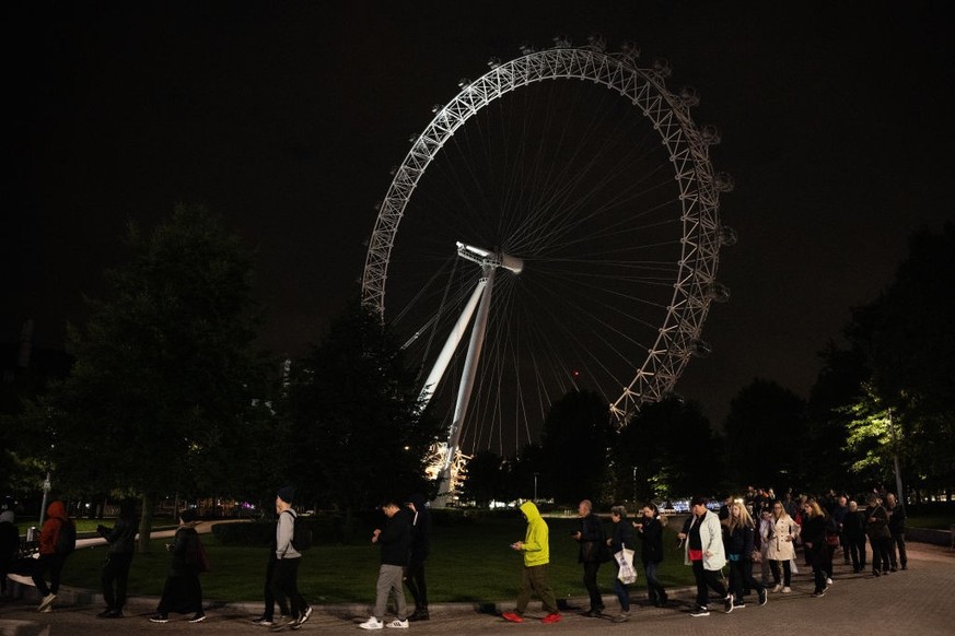 LONDON, ENGLAND - SEPTEMBER 15: Well-wishers stand in the queue by the London Eye for the Lying-in State of Queen Elizabeth II on September 15, 2022 in London, England. Queen Elizabeth II is lying in ...