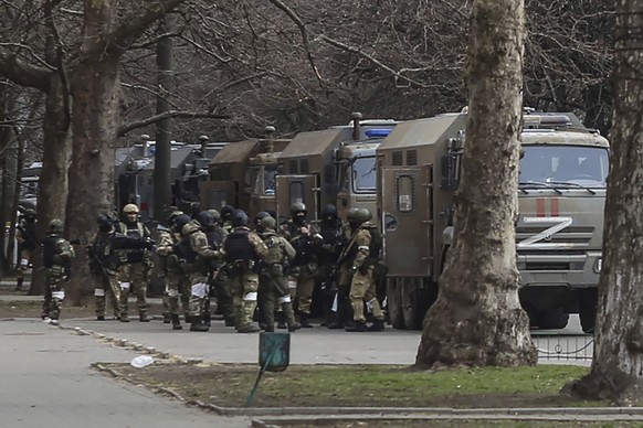 FILE - Russian army soldiers stand next to their trucks during a rally against Russian occupation in Svobody (Freedom) Square in Kherson, Ukraine, on March 7, 2022. As Russian forces sought to tighten ...