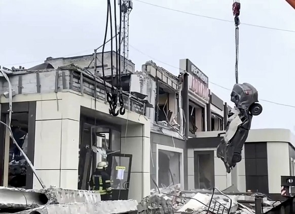 epa11124389 A handout still image taken from a handout video provided by the Russian Emergencies Ministry shows rescue worker clearing debris outside a bakery following shelling in Lysychansk, Russian ...
