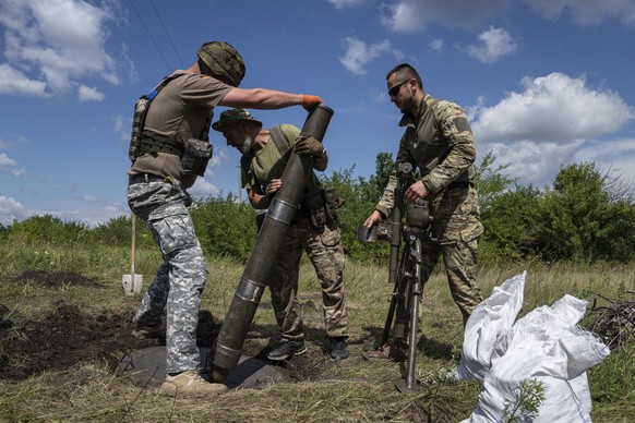 Ukrainian servicemen set up a mortar at the frontline in Kharkiv region, Ukraine, Saturday, July 23, 2022. (AP Photo/Evgeniy Maloletka)