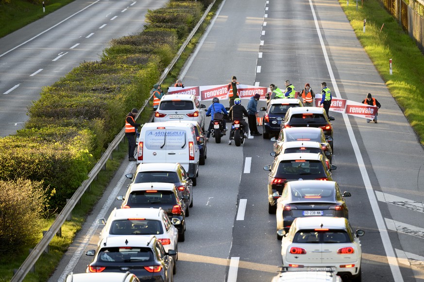 Climate activist sit down in the road during the &quot;Renovate Switzerland&quot; a roadblock action, A1a freeway, in Lausanne, Switzerland, Monday, April 11, 2022. (KEYSTONE/Laurent Gillieron)