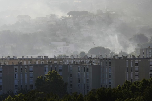 CORRECTS TO CASTELLANE, NOT CATELLANE - Smoke rises behind buildings during wildfire Tuesday, July 8, 2025 in La Castellane district of Marseille, southern France. (AP Photo/Lewis Joly)
France Marseil ...