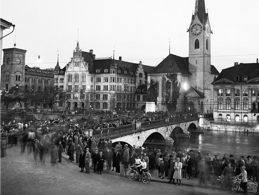 Le soir du 8 mai 1945, la population zurichoise célèbre la fin de la Seconde Guerre mondiale. En arrière-plan, l'église Fraumünster.
