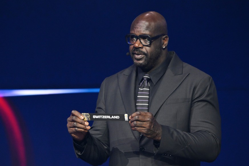 former NBA player Shaquille O&#039;Neal holds up Switzerland after drawing from a pot during the draw for the 2026 soccer World Cup at the Kennedy Center in Washington, Friday, Dec. 5, 2025. (Mandel N ...