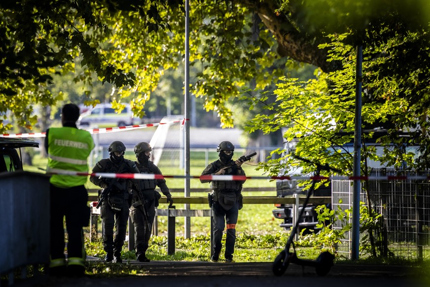epa13199976 Armed police officers stand guard near the Schachen horse racing track following a shooting, in Aarau, Switzerland, 30 August 2026. One person was killed and five others were injured in an ...