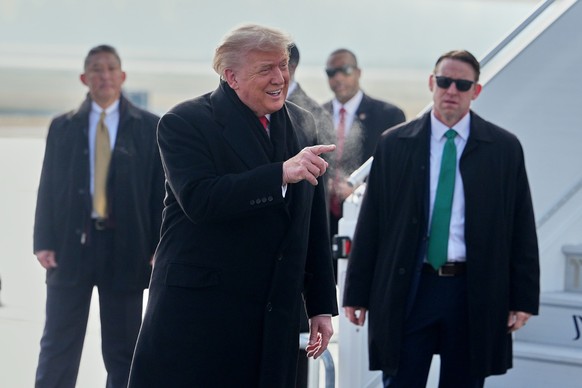 President Donald Trump, center, points his finger as he steps off Air Force One after arriving at Zurich International Airport for the World Economic Forum, Wednesday, Jan. 21, 2026, in Zurich, Switze ...