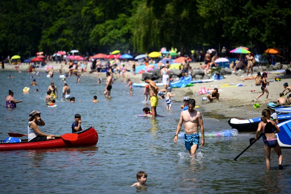epa10022004 People enjoy the day on the shore of the Lake Geneva at the Vidy beach (plage de Vidy) in Lausanne, Switzerland, 19 June 2022. People flocked to parks and pools across Europe for a bit of  ...