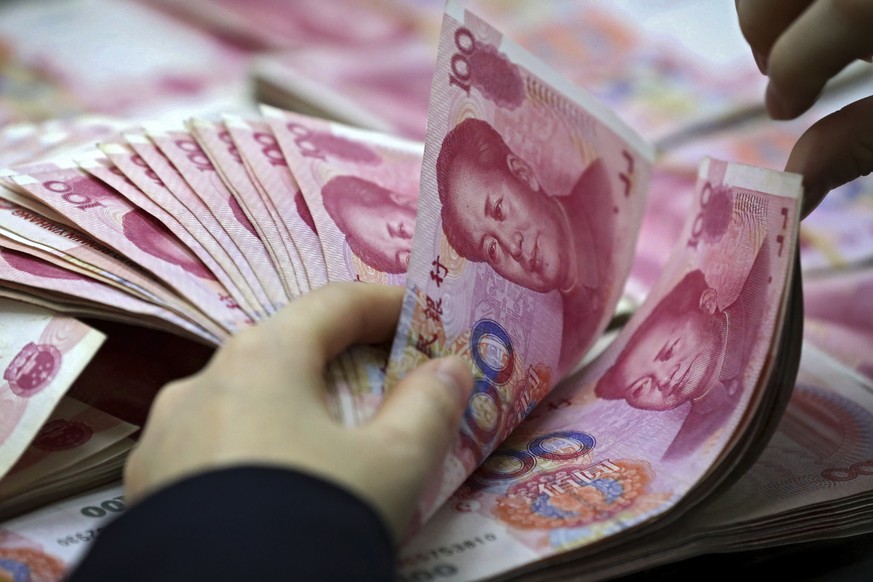 FILE - A clerk counts Chinese currency notes at a bank outlet in Huaibei in central China&#039;s Anhui province, Nov. 25, 2016. Argentina ?s government announced Wednesday, April 26, 2023, that it wil ...