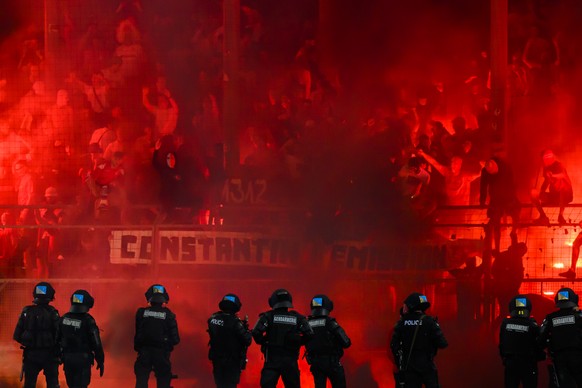 Les supporters valaisans allument des fumigenes davant les policiers anti-emeute de la police vaudoise lors du match retour du barrage de promotion en Super League et de relegation en Challenge League ...