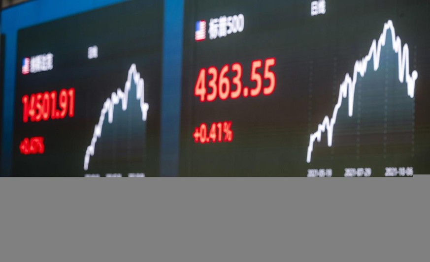 epa09510799 A woman gestures in front of the screen showing newest stock exchange and economic data in Shanghai, China, 07 October 2021. A debt crisis and rising bond yields of China Evergrande Group  ...