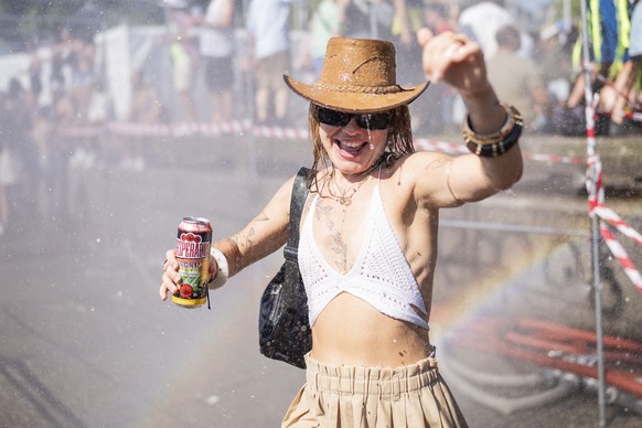 epa12291168 People cool off at a water sprayer during the 32nd Street Parade in Zurich, Switzerland, 09 August 2025. The annual dance music event Street Parade runs this year under the slogan &#039;Li ...