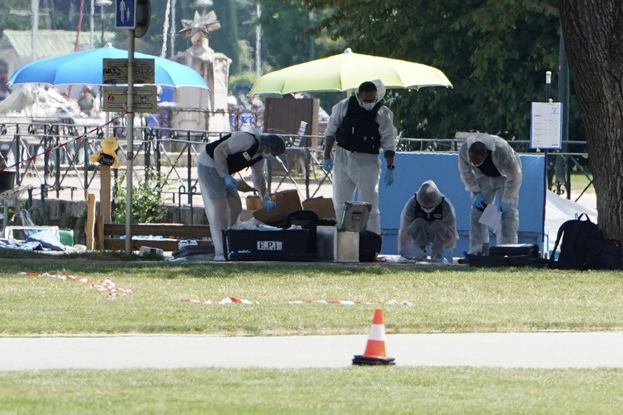 Police officers investigate at the scene after a knife attack Thursday, June 8, 2023 in Annecy, French Alps. A man with a knife stabbed several very young children, including at least one in a strolle ...