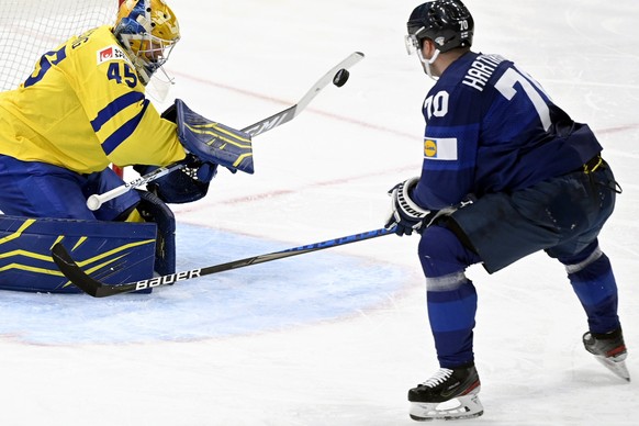 Goalkeeper Magnus Hellberg, left, of Sweden tends the net against Teemu Hartikainen of Finland during the 2022 IIHF Ice Hockey World Championships preliminary round group B match between Finland and S ...
