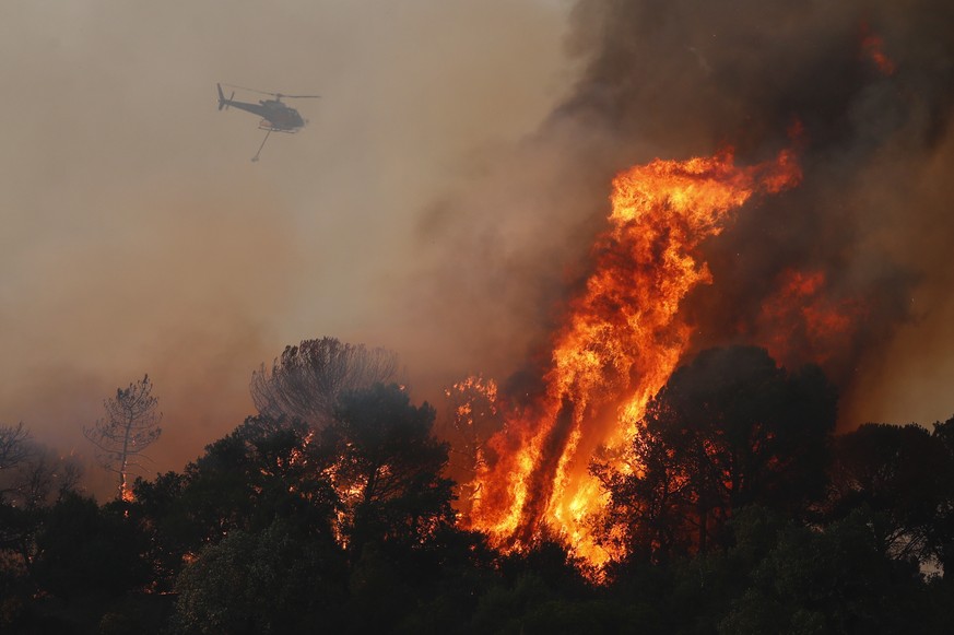 epa09418196 A firefghting helicopter battles a wildfire around the village of Cannet des Maures, France, 17 August 2021. Firefighters are battling wildfires and thousands of residents are evacuated in ...