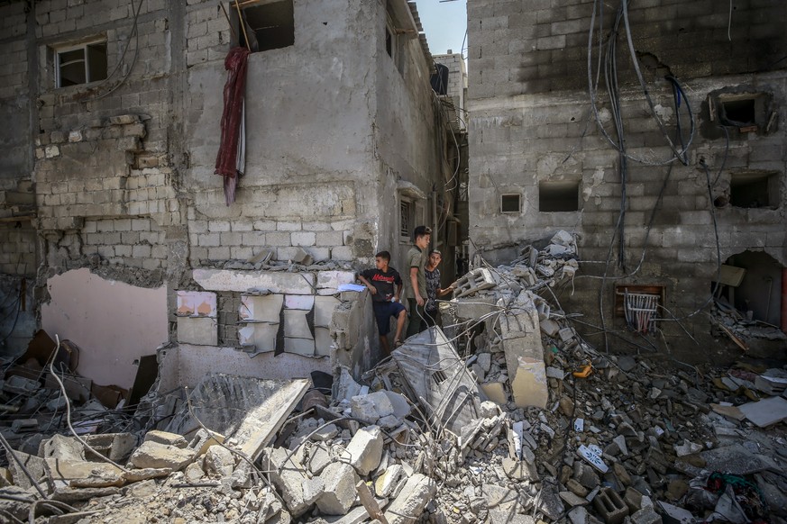 epa10110111 Palestinians inspect a destroyed house after an Israeli air strike in Rafah town, Gaza Strip, 07 August 2022. A third day of tensions between Palestinian militants in Gaza and Israeli forc ...